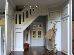 an entry way to a house with wooden floors and white walls, along with a coat rack on the wall