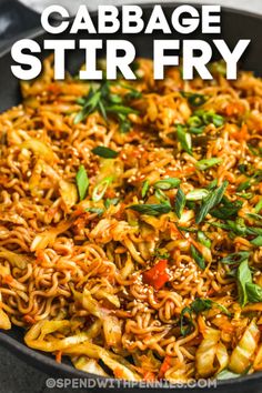 a skillet filled with stir fry noodles and garnished with green leaves, on top of a white table