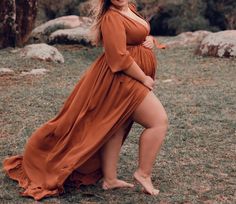 a pregnant woman posing for a photo in an orange dress with her legs spread out