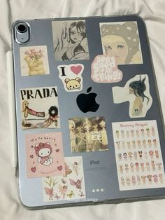 an apple laptop with many stickers on the back and side of it's cover