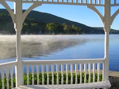 a white bench sitting on the side of a lake