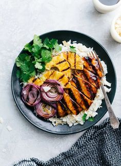 grilled chicken with rice and onions on a plate