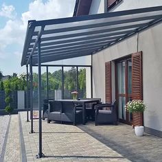 a patio covered in black furniture next to a building