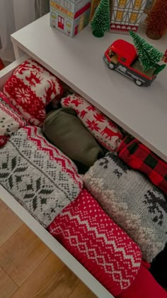 a white table topped with lots of christmas sweaters and toys on top of it