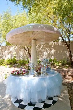 a table that has some food on it in the middle of a yard with trees