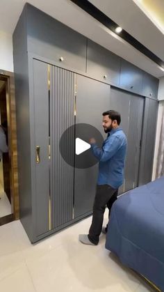 a man standing next to a bed in a room with lockers on the wall