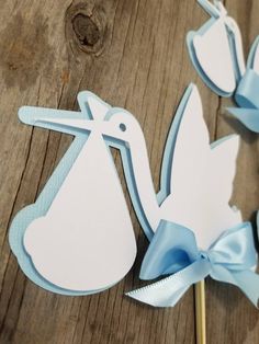 two blue and white stork shaped lollipops on top of a wooden table