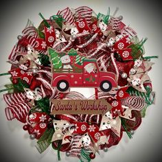 a christmas wreath with a red truck and santa's workshop written on the front