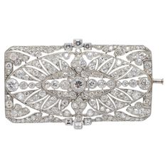 Introducing a stunning Art Deco brooch crafted from platinum. This exquisite piece exudes intricate elegance, capturing the essence of the Art Deco era with its delicate design and dazzling diamonds. Each diamond, expertly cut in the old European style, contributes to the brooch's captivating allure. The diamonds, ranging in size but expertly proportioned, create a harmonious and balanced arrangement that draws the eye effortlessly. At the center, a striking diamond of approximately 0.50 carats commands attention, flanked by diamonds on either side, each weighing around 0.30 carats. All diamonds exhibit exceptional clarity, boasting a color grade of F and a clarity grade of VS2, ensuring brilliance and sparkle with every glance. This Art Deco brooch is not just a piece of jewelry but a tim Luxury Platinum Brooches As Gift, Luxury Platinum Brooches For Gift, Luxury Silver Brilliant Cut Brooches, Ornate Diamond Brooch With Intricate Design, Ornate Diamond Brooches With Intricate Design, Elegant Silver Platinum Brooches, Classic Platinum Brooch With Brilliant Cut, Luxury Platinum Brooches, Ornate Diamond Brooch For Formal Occasions