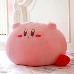 a pink stuffed animal sitting on top of a bed