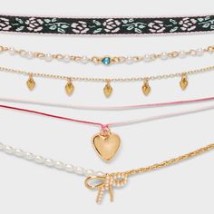 Up your necklace game with the Girls' 5pk Heart and Bow Charms Choker Necklace Set from art class™. Includes one black fabric necklace, four dainty chain necklaces featuring various designs and two embellished with white pearls in among chain links with a four-inch extender chains help you find the perfect fit. The set of 5 provides versatile options, making it easy to mix and match with a variety of outfits. Elevate your little one’s style with these chic necklace collection from art class. art Necklace Game, Dainty Chain Necklace, Charm Choker Necklace, Chic Necklace, Fabric Necklace, Necklace Collection, Choker Necklace Set, Dainty Chain, Elastic Hair Ties