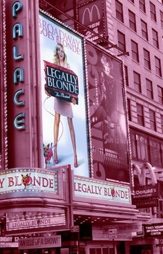 the marquee for legally blonde is lit up in red and pink colors with advertisements on it