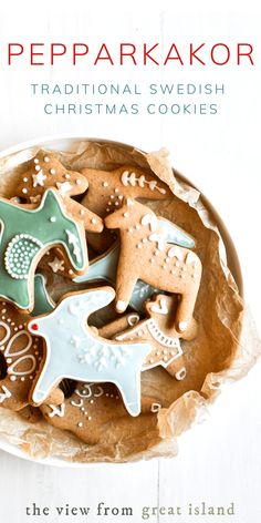 a bowl filled with christmas cookies on top of a white wooden table next to a book cover