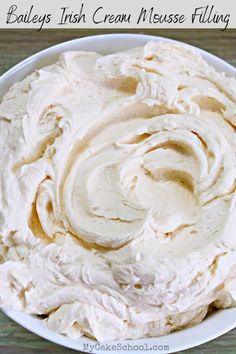 a white bowl filled with whipped cream on top of a wooden table and text overlay that reads bailey's irish cream cheese filling