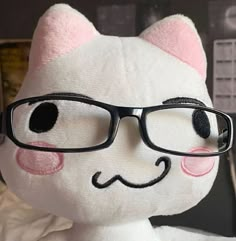 a white stuffed cat with glasses on it's face