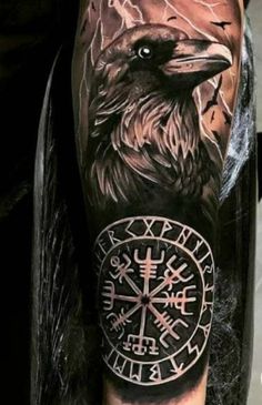 a man's arm with an eagle and compass tattoo on it