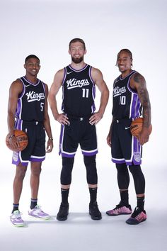 three basketball players are posing for a photo