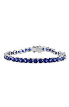 Round-cut lab-created blue sapphires are prong-set along this timeless tennis bracelet. 7 1/4" inner circumference; 1/8" width Total lab-created-blue-sapphire weight: 14.50ct. Sterling silver/lab-created blue sapphire Imported Blue Tennis Bracelet For Anniversary, Classic Sapphire Tennis Bracelet For Anniversary, Blue Diamond Bracelet With Prong Setting For Anniversary, Classic Blue Tennis Bracelet As Gift, Sapphire Tennis Bracelet With 17 Jewels, Sapphire Tennis Bracelet For Anniversary, Blue Sapphire Diamond Bracelet, Blue Tennis Bracelet With Prong Setting For Formal Occasions, Anniversary Sapphire Tennis Bracelet