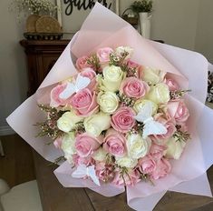 a bouquet of pink and white flowers on a table