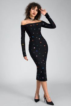 a woman wearing a black dress with multicolored stars on the sleeves and shoulders