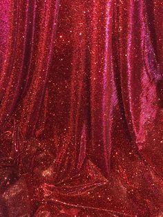 a red curtain with some shiny glitter on it