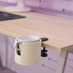 a coffee cup is sitting on the edge of a desk