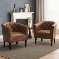 two brown chairs sitting on top of a rug in front of a white fire place