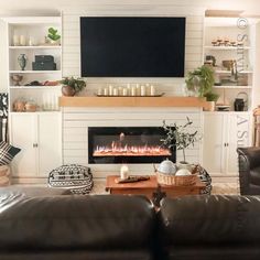 a living room filled with furniture and a flat screen tv mounted above a fire place