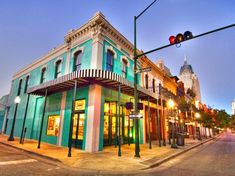 a street corner with a traffic light and storefronts on the side of it