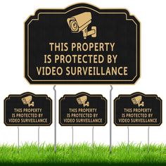 this property is protected by video surveillance sign with lawn signs in the grass behind it