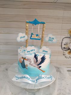 a birthday cake decorated with an image of a stork flying over the clouds