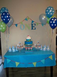 a blue table topped with cake and balloons