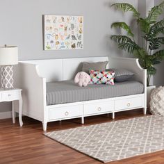 a white daybed with drawers and a teddy bear