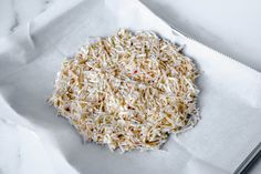 a pile of shredded white rice sitting on top of a piece of paper next to a knife