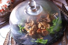 a glass dome with food in it on a table