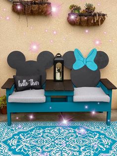 a blue bench with mickey mouse ears on it