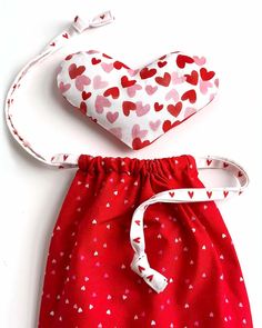 two bags with hearts on them sitting next to each other in red and white fabric