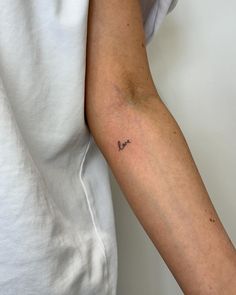 a woman's arm with a small tattoo on the left side of her arm