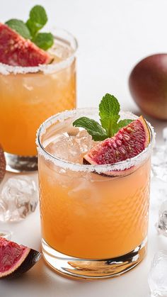 two glasses filled with fruit and ice on top of a table