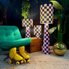 two yellow roller skates sitting next to each other in front of a green chair