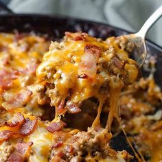 a spoon full of cheesy ground beef casserole with cheese and bacon