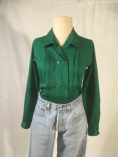 "vintage early 1980s women's blouse Avon fashions, made in USA 65% polyester, 35% cotton solid forest green button up, collared long sleeve w/button cuff double row button up knife pleats down front yoke hem good vintage condition, light wear labeled size 5/6, see below measures, lying flat, shoulder-13 1/2\" chest-17\" sleeve-23\" length-25\"     We do not offer returns or refunds unless something is grossly misrepresented. Please contact us within 2 business days of receiving to discuss any possible returns for this reason. We do not offer refunds for your shipping fees. Please feel free to contact us with any questions you may have about an item prior to purchase and we will gladly answer them." Affordable Retro Green Shirt, Green Long Sleeve Blouse With Button Closure, Fitted Green Blouse With Button Closure, Retro Relaxed Fit Blouse For Fall, Retro Green Tops For Fall, Green Buttoned Shirt For Fall, Green Collared Shirt For Winter, Green Fall Shirt With Buttons, Retro Long Sleeve Relaxed Fit Blouse