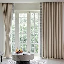 an elegant living room with large windows and marble furniture in the center, along with white walls