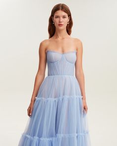 Dreamy tulle dress in light blue color with a light ruffled tulle maxi skirt. This dress has a heart-shaped boned semi-transparent bodice with built-in cups and a corset back, which makes the silhouette fitted and elegant. The A-line maxi skirt is made from multiple layers of delicate tulle that emphasize the hourglass silhouette. The waistline is adorned with a silver belt with Milla’s signature.This dress comes with straps, adding an elegant touch. Details: Material: Tulle Fabric composition: Sheer Tulle Maxi Dress For Cocktail, Sheer Tulle Maxi Dress For Cocktail Events, Sheer Tulle Maxi Dress For Cocktail Parties, Light Blue Maxi Dress For Gala, Fitted Bodice Midi Dress With Tulle Skirt, Midi Dress With Fitted Bodice And Tulle Skirt, Midi Dress With Tulle Skirt And Fitted Bodice, Summer Tulle Dress With Pleated Bodice, Gala Tulle Midi Dress With Tulle Skirt