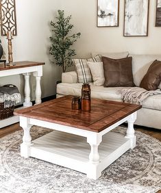 a living room with a couch, coffee table and pictures on the wall above it