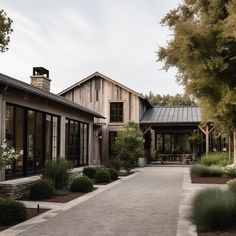 a large house with lots of windows and plants in front of the entrance to it