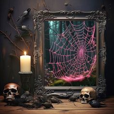 there is a spider web in the frame and two skulls on the table next to it