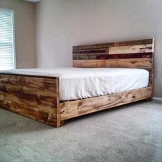 a bed frame made out of wood in a bedroom