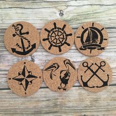 four cork coasters with black and white images of ships, anchors, compasses