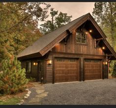 a log cabin with two garages in the woods